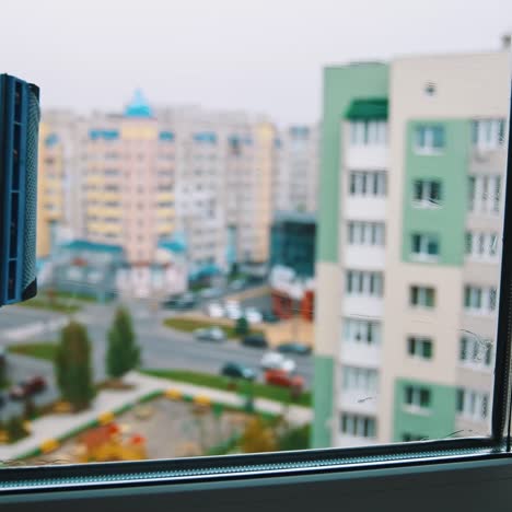 polishes windows with sponge