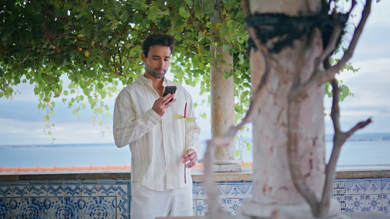 novio romántico esperando fecha sosteniendo una flor en el punto de vista. hombre comprobando el teléfono