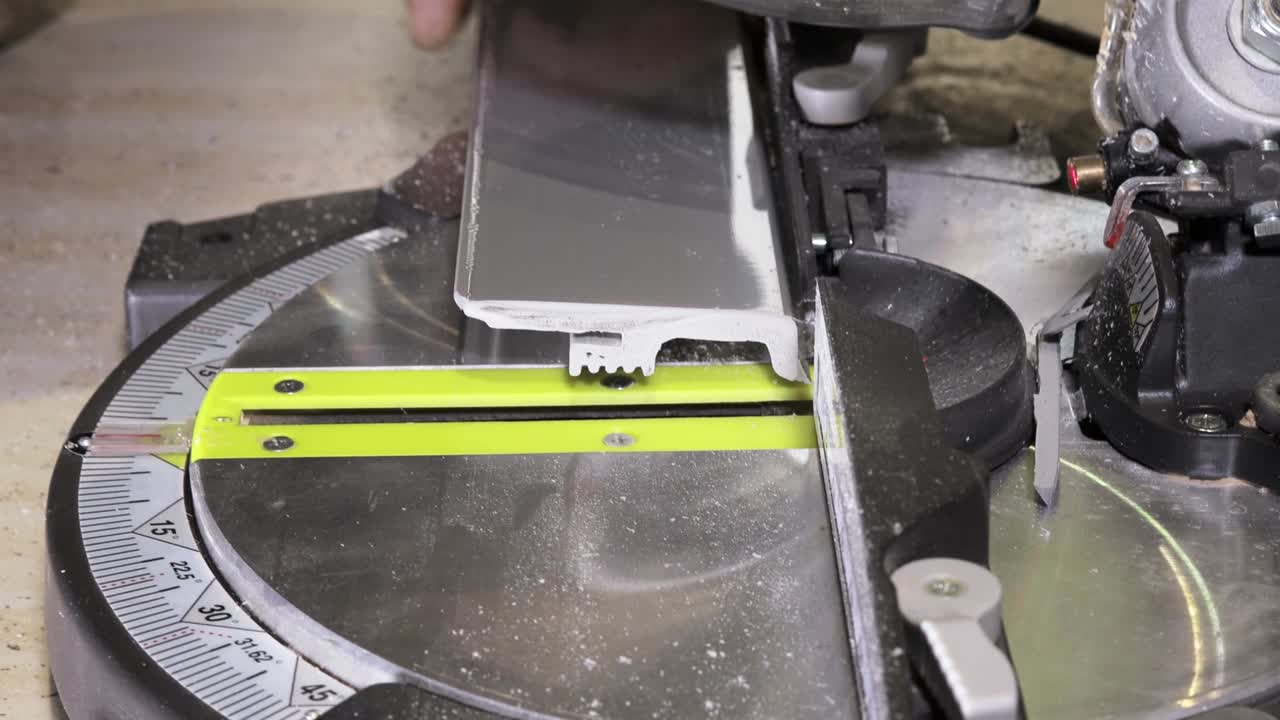 рабочий режет подставку на круговой пиле перед установкой.