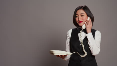 Asiatische-Rezeptionistin-Beantwortet-Festnetz-Telefonanruf-Im-Studio