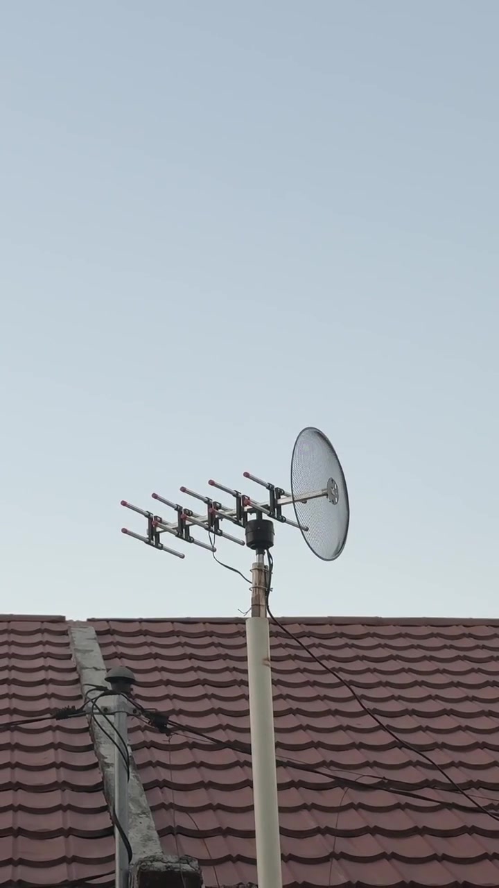 Antenna televisiva montata su un tetto residenziale.
