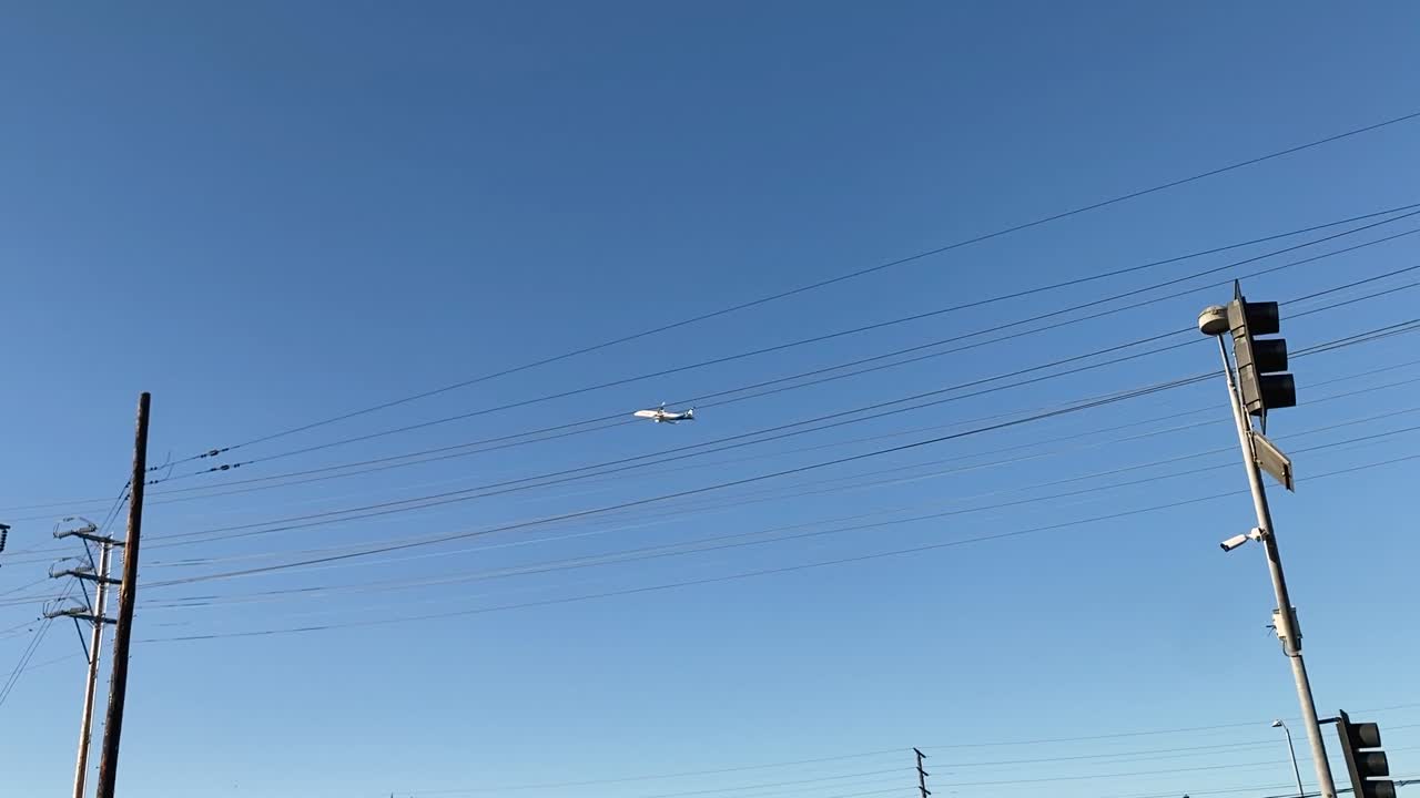 느슨한 패닝에서 꽃의 선반 초점으로 이륙하는 비행기의 도시 환경에서 거리 수준의 넓은 시야