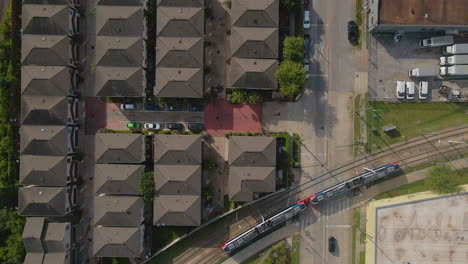 aerial view of neighborhood near train tracks with train passing in houston, texas, usa