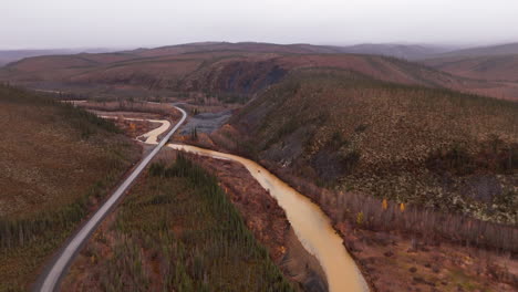 dempster highway across ogilvie river in yukon territory, northwestern canada. aerial pullback shot