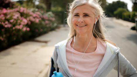 senior woman listening to music and resting after jogging workout