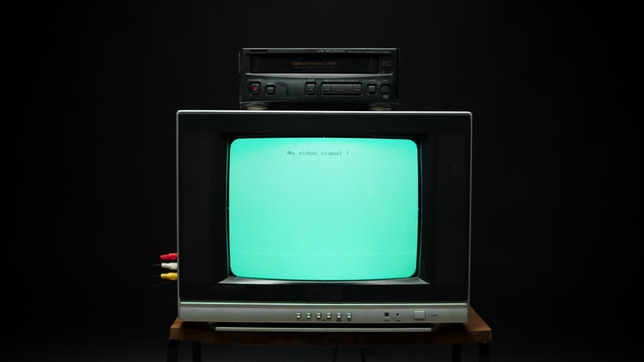 Old retro square television with blue screen on black background. Old-fashioned TV with cassette video recorder, tv setting concept, ripples and interference, searching channel