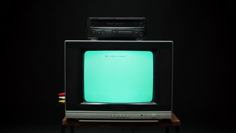 old retro square television with blue screen on black background. old-fashioned tv with cassette video recorder, tv setting concept, ripples and interference, searching channel