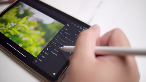 editing some images using a computer software using a portable electronic gadget and a digital stylus pen