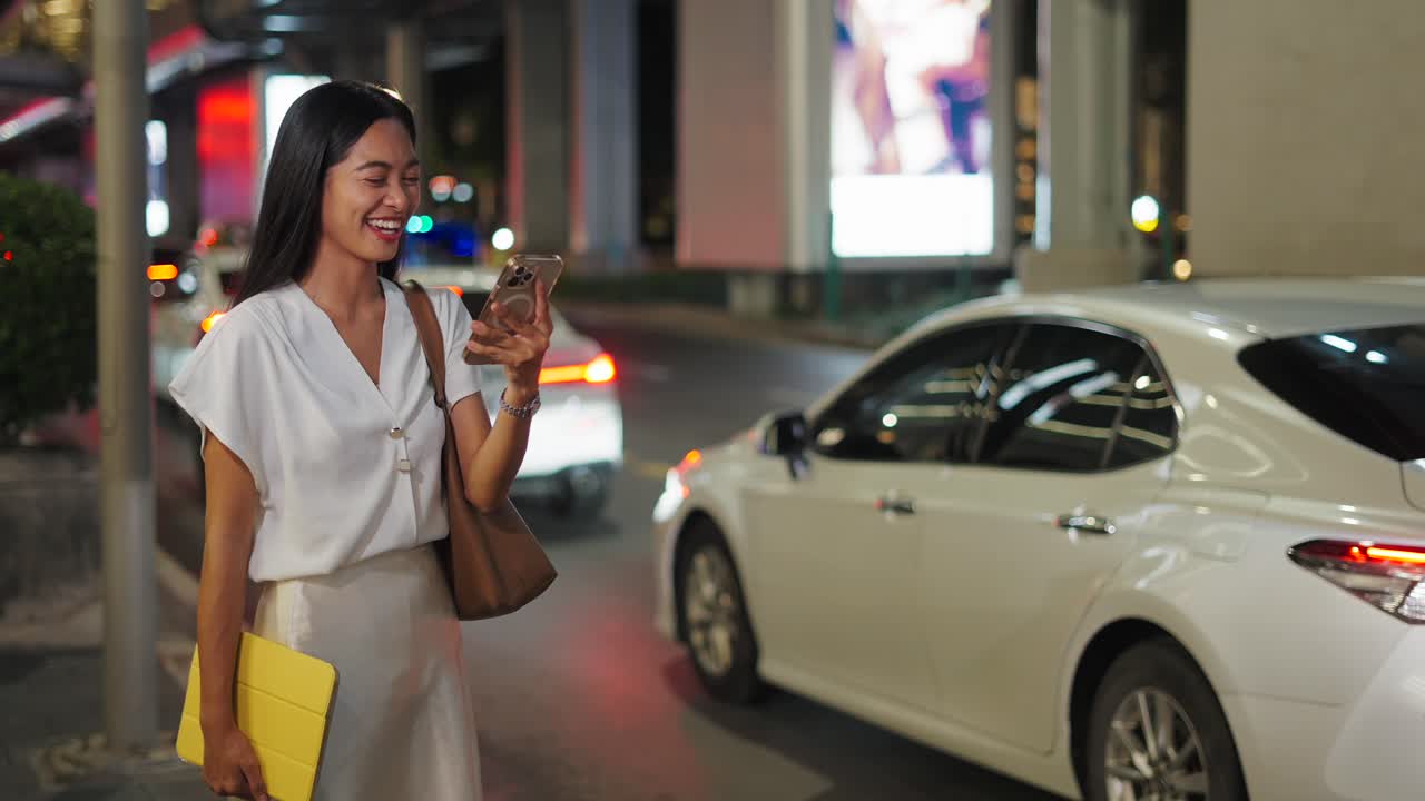 Businesswoman using smartphone at night in city street