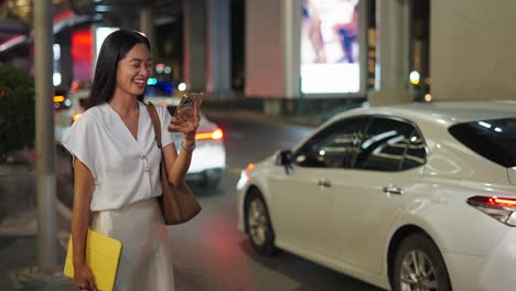businesswoman using smartphone at night in city street