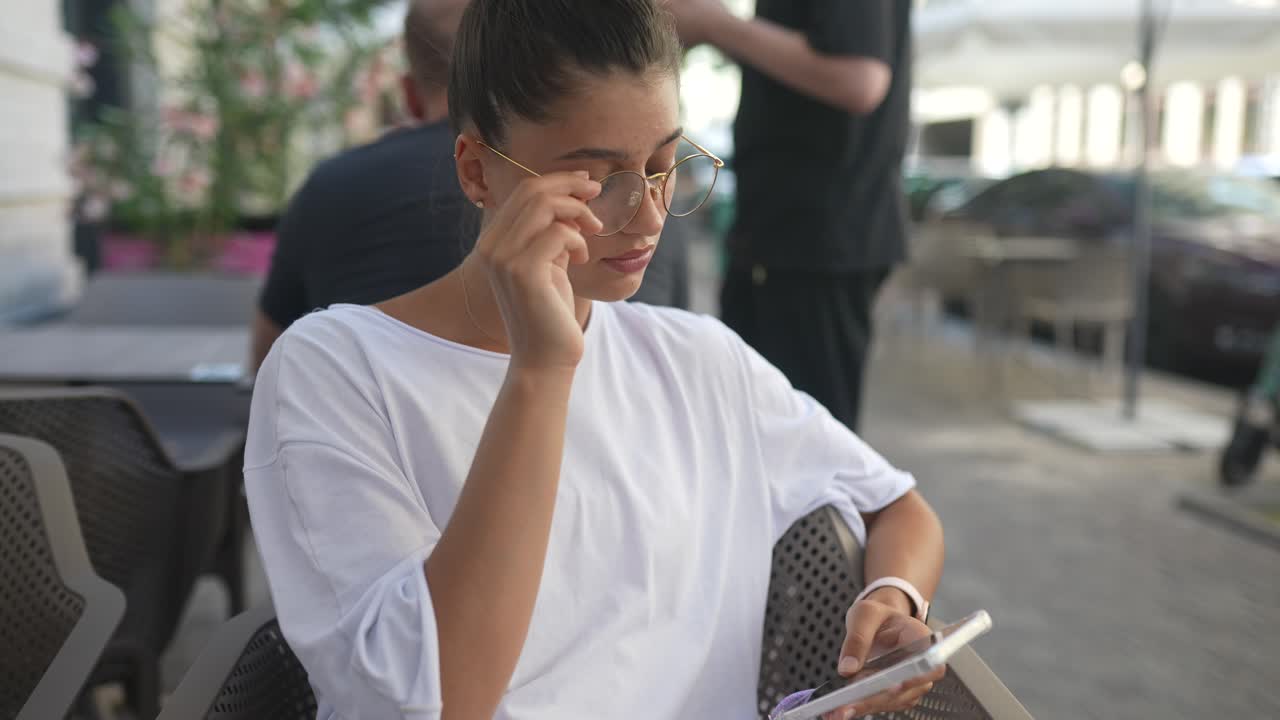 Young woman using phone at a cafe