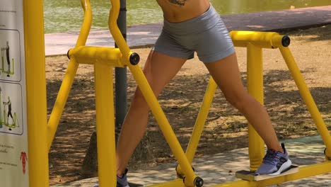 woman exercising on outdoor exercise machine in a park