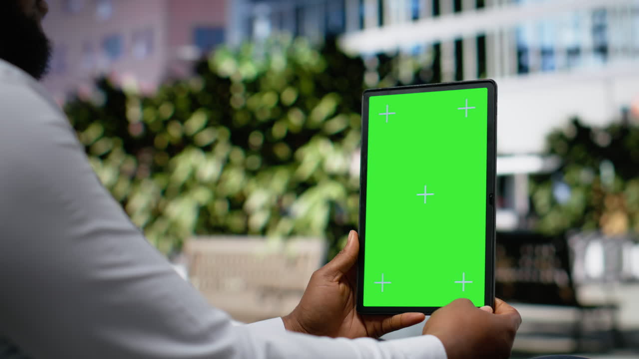 Vertical chroma key with african american seated on a bench in urban park