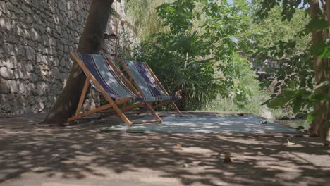 Slow-revealing-shot-of-beach-chairs-sitting-in-a-secluded-spot-beside-the-lez-river