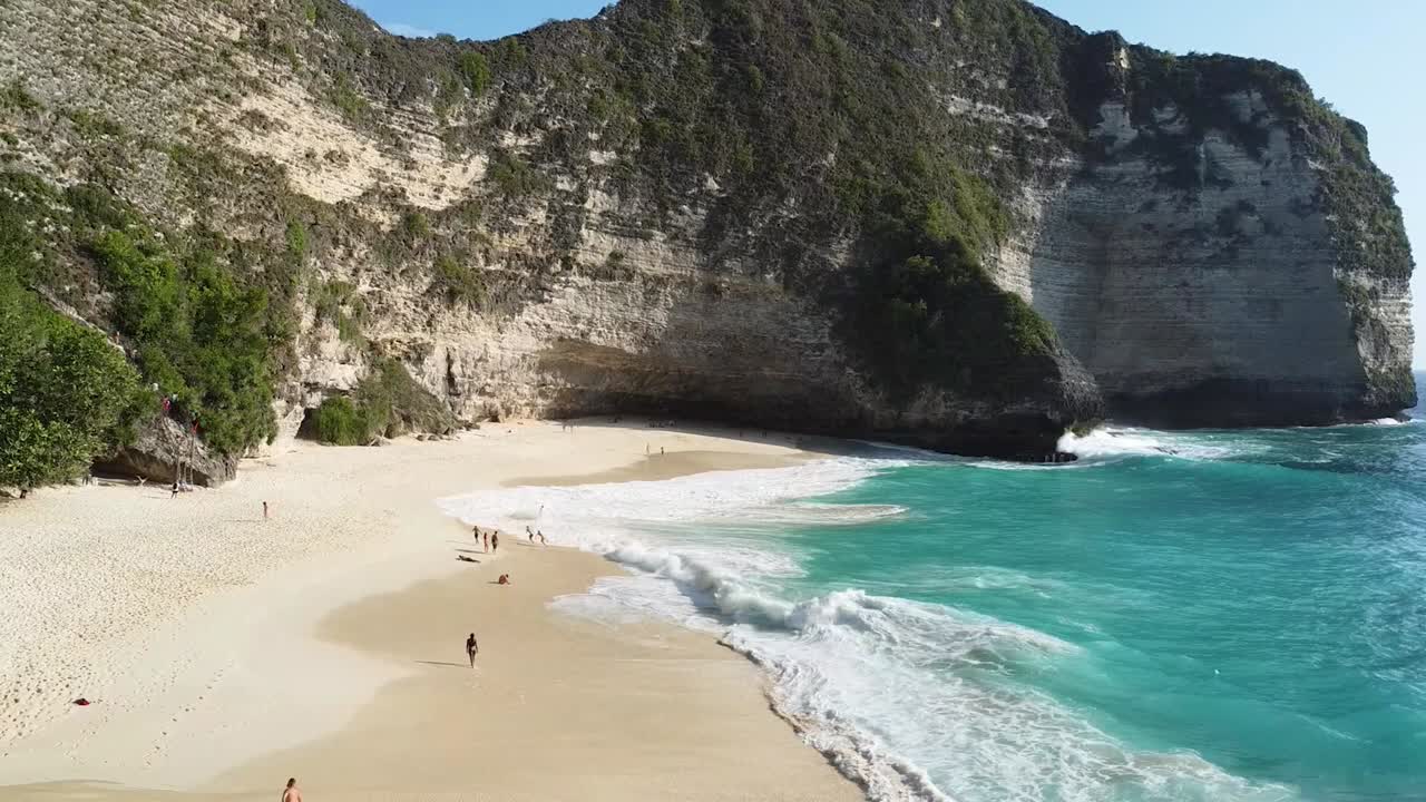 Kelingking Beach with Turquoise Waves Along the Coastal Cliffs of Bali, Indonesia. Aerial Drone Shot.
