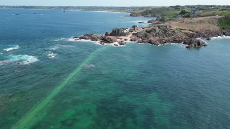 Causeway-visible-under-high-tide-La-Corbière,-Jersey,-drone,aerial