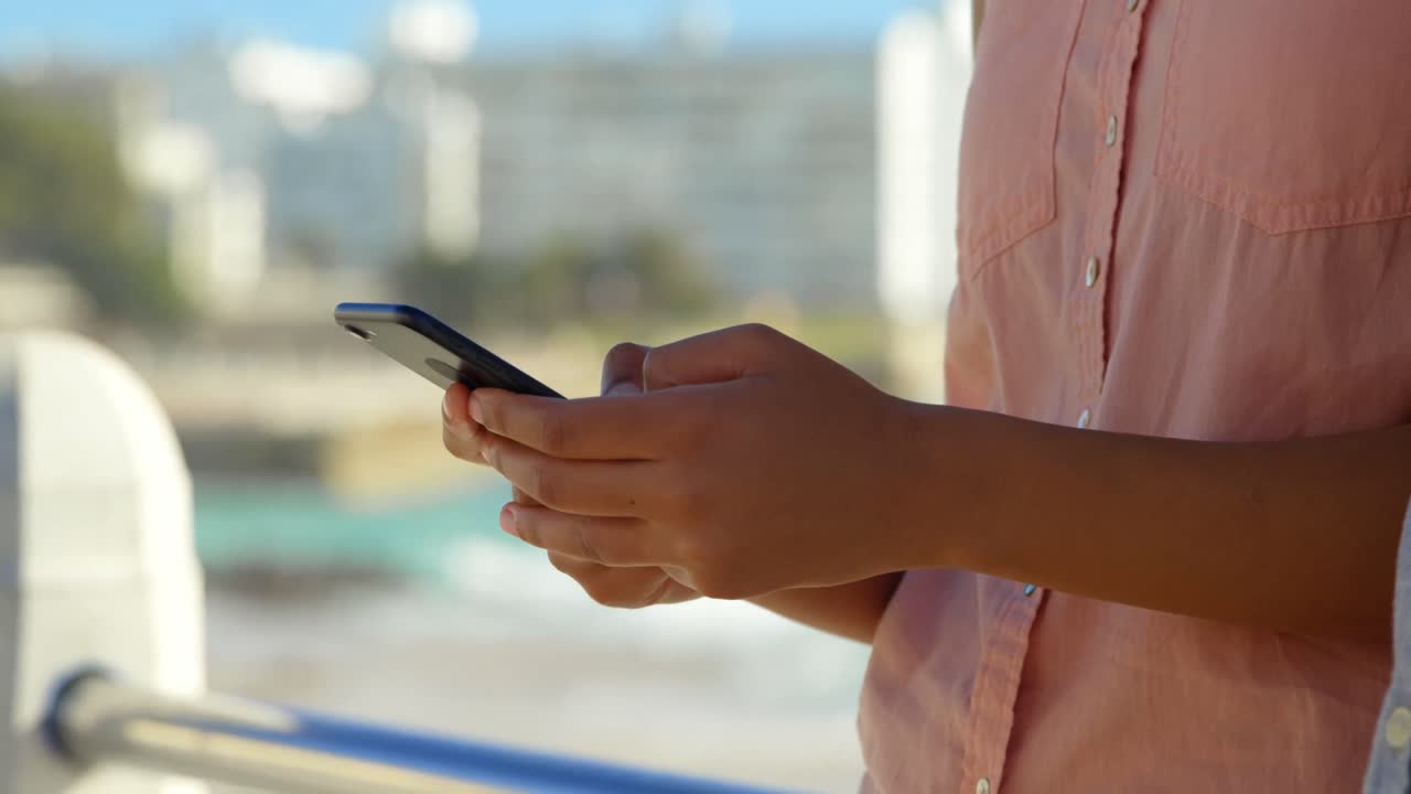 Close-up of woman using mobile phone near railings 4k