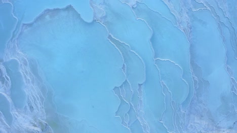 Aerial-view-of-Pamukkale-geothermal-springs,-travertine-terraces