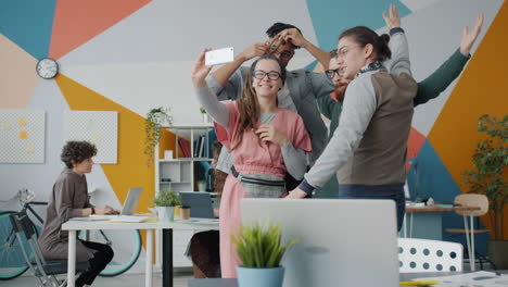 happy team taking a selfie in the office