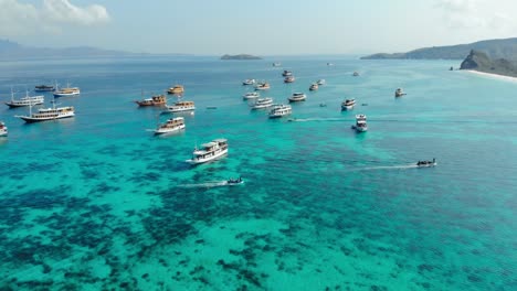 Flug-über-Türkisfarbenes-Wasser-Und-Boote-Von-Pantai-Merah-Auf-Der-Insel-Padar-Im-Komodo-Nationalpark,-Indonesien