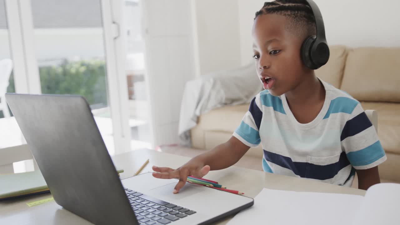 African american boy using laptop for online lesson, in slow motion