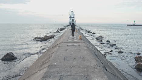 man in black walking down to the foggy lighthouse