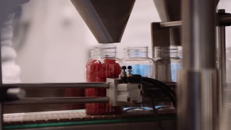 gummy bear vitamin supplements dropped into bottles on automated assembly line