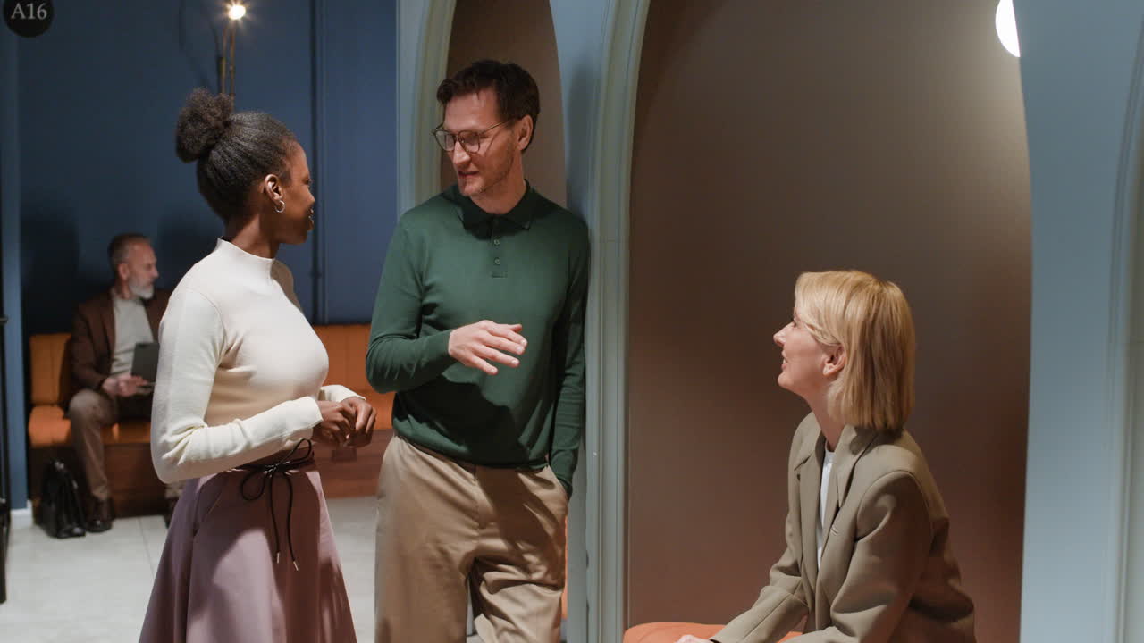 Group of diverse professionals engaged in conversation in a modern office lounge area