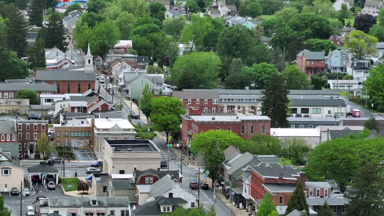 Aerial view of a charming American town with brick buildings, tree-lined streets and historic church. Traditional and modern architecture creates a cozy, picturesque community atmosphere. Manheim,PA.