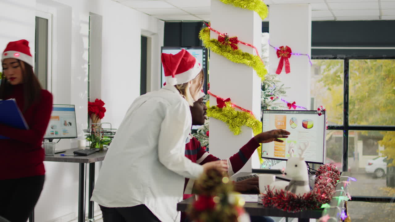 Festive office environment with employees in Santa hats