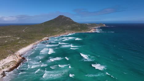 pointed cape of good hope mountain with azure blue wave swell in foreground