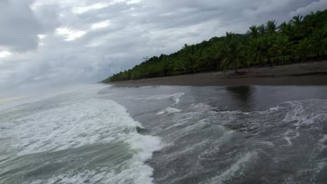 Luftwagen-In-Schäumenden-Meereswellen,-Die-An-Bewölkten-Tagen-In-Dominicalito-Beach,-Costa-Rica,-Auf-Die-Küste-In-Der-Nähe-Von-Dschungelvegetation-Treffen