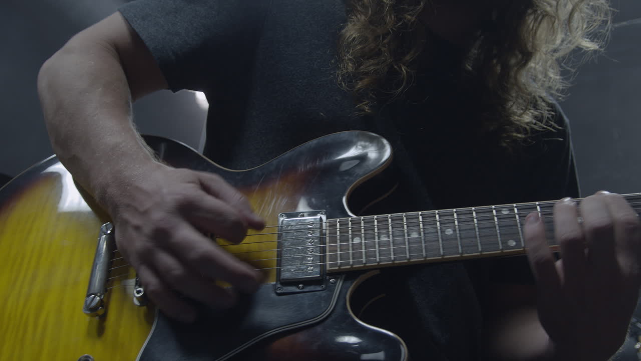 Profesyonel uzun saçlı müzisyen kayıt stüdyosunda gitar çalıyor (Sinematik Ağır Çekim)