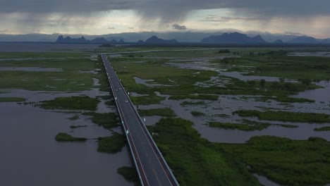 Sun-setting-over-vehicles-travelling-on-Chaloem-Phrakiat-80-Phansa-Bridge,-South-Thailand