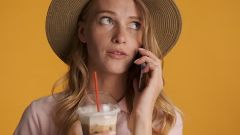 caucasian woman having phone call while drinking iced coffee.