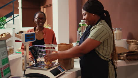 merchant using scale to weight fruits and veggies for client