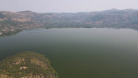 aerial clip rotating over the top of a mountain on the lake of kastoria, in northern greece