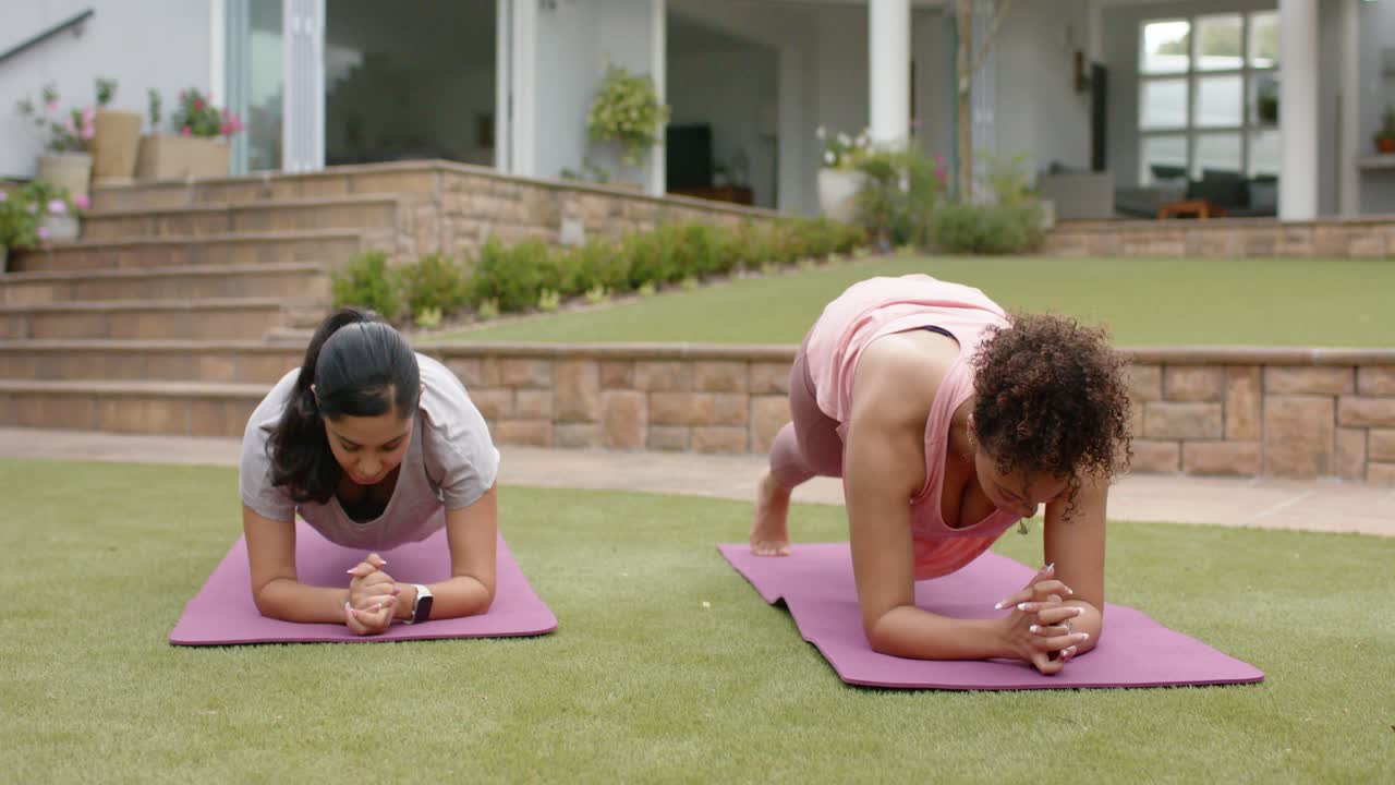 Two women holding forearm plank on purple mats, right woman starting knee drives for fitness