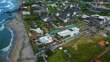 cinematic drone footage of berawa beach in canggu, bali with beautiful landscape, expensive hotels and villas through calm weather
