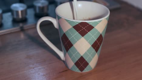 taza de cerámica con patrón de argyle en la encimera de madera