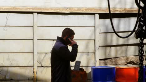 male worker talking on mobile phone in workshop 4k