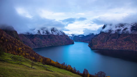 Wolkengebilde-Auf-Den-Klippen-Mit-Blick-Auf-Einen-Tiefen-Fjord-Mit-Schafen-Am-Hang-Im-Herbst---Zeitraffer