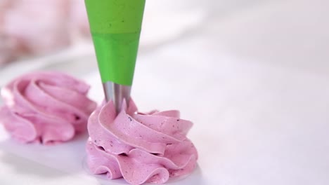 decorating pink marshmallows with piping bag