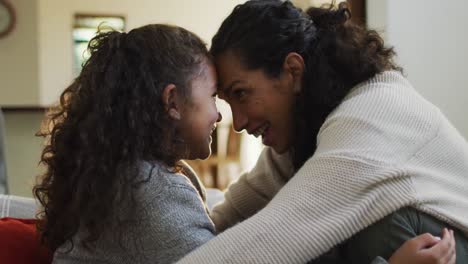 happy mixed race mother and daughter hugging an smiling