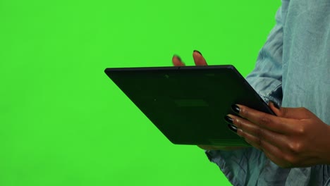 una mujer negra trabaja en una tableta - primer plano - estudio de pantalla verde