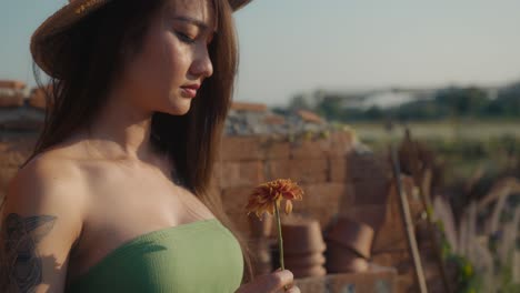 woman with flower in a rural setting
