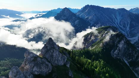 imágenes aéreas de drones sobre las montañas de los dolomitas en la región de tirol del sur de italia en un día parcialmente nublado, con colinas verdes y árboles visibles