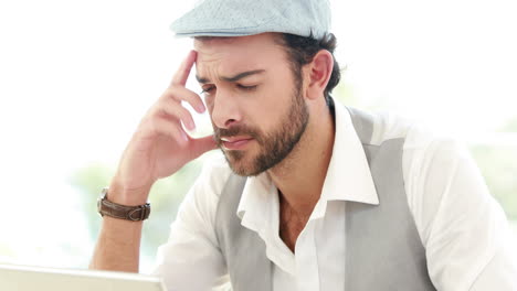 frustrated hipster businessman using his laptop