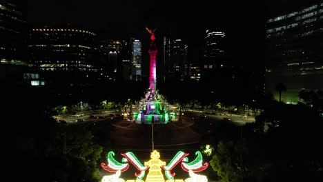 drone shot of angel de la independencia iluminated at night during dia de la independencia in mexico city