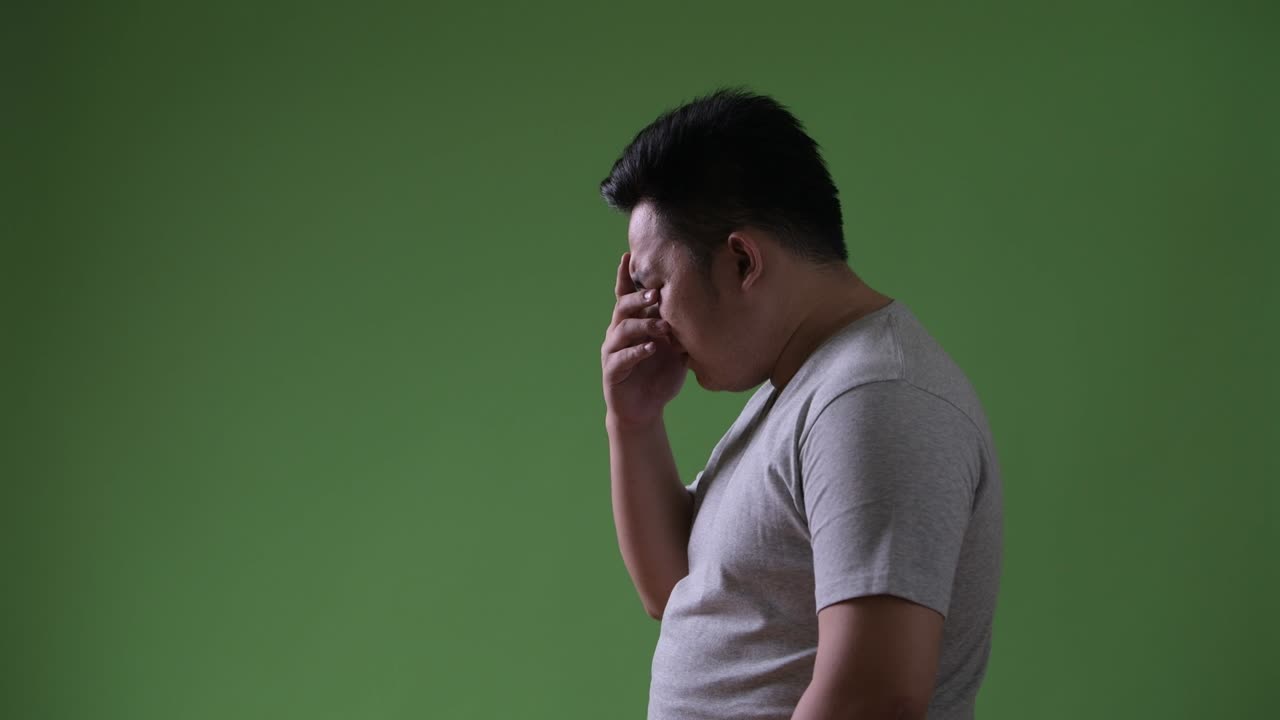 초록색 배경에 젊은 잘생긴 과체중 아시아인